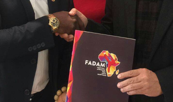 Two people shaking hands and holding a FADAM press kit